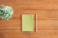 pexels photo 733854 733854 Flat lay of green notebook and pencil on wooden desk with plant. Perfect for creativity and organization themes.